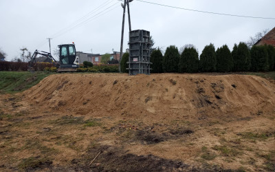 zdjęcie terenu budowy, słup energetyczny w tle
