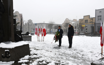 dwie osoby stojące na rynku w Margoninie przed pomnikiem